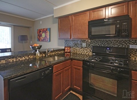 a kitchen with black appliances and granite counter tops